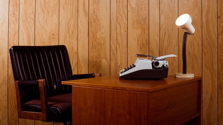 Writer's desk beside wood paneling