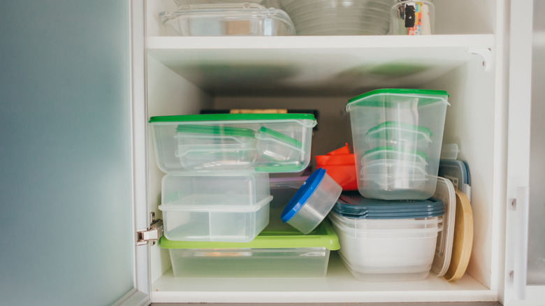 Cabinet filled with empty mismatched plastic food containers