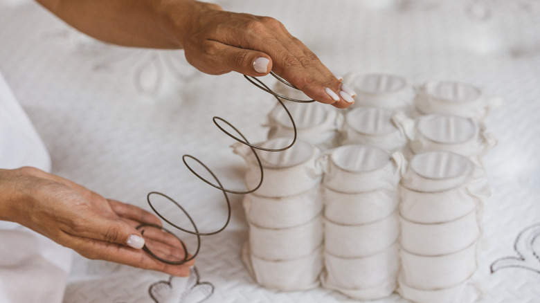 person holding mattress spring