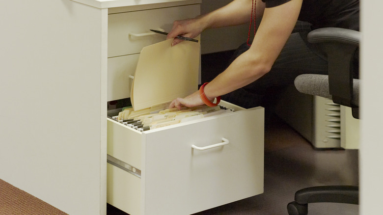 Person searching through filing cabinet