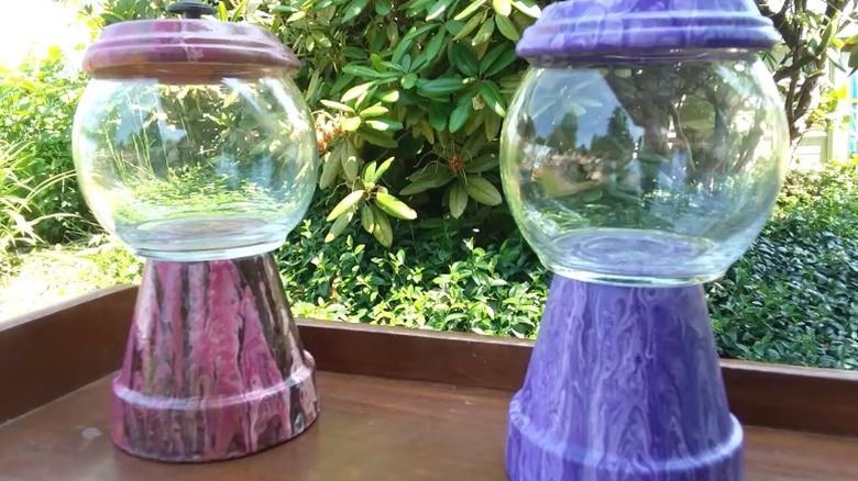 Purple and pink paint-poured terracotta pot candy jars on outdoor table