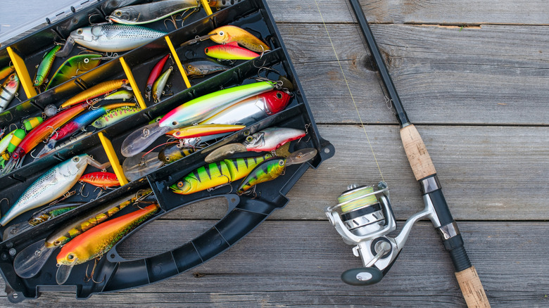 Small tackle box and a fishing rod on a pier.