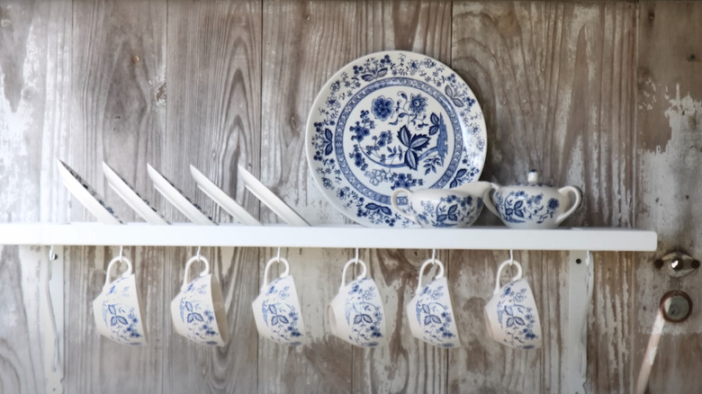 Old shutter repurposed as a rack for dinnerware