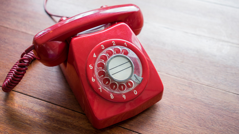 Retro vintage red landline telephone rests on a table