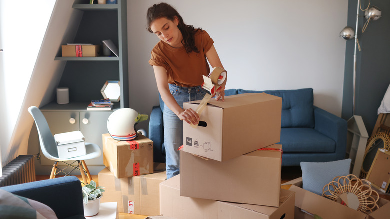 person taping cardboard box