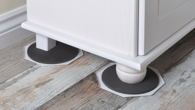 Hardwood furniture sliders are placed under a cabinet's legs