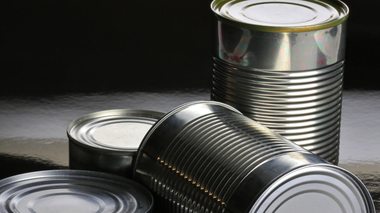 Pile of shiny metal soup cans on a black background