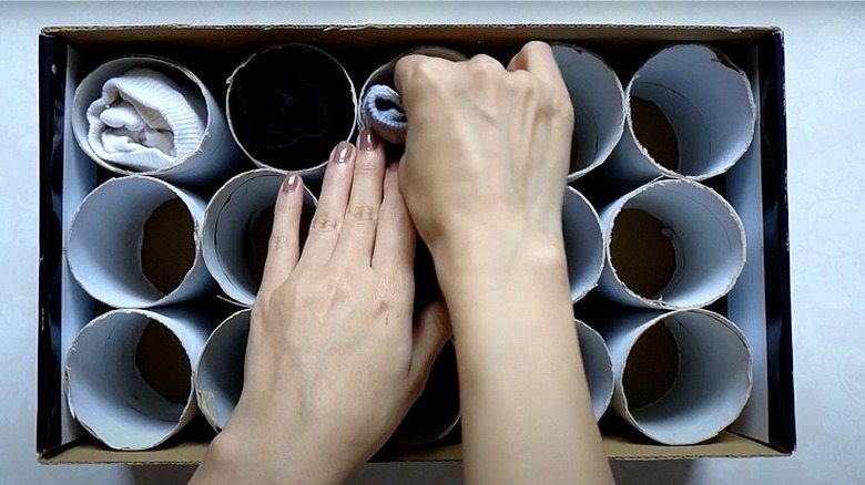 person organizing socks using toilet paper tube