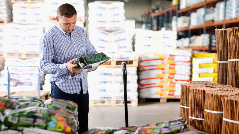 man shopping for potting soil