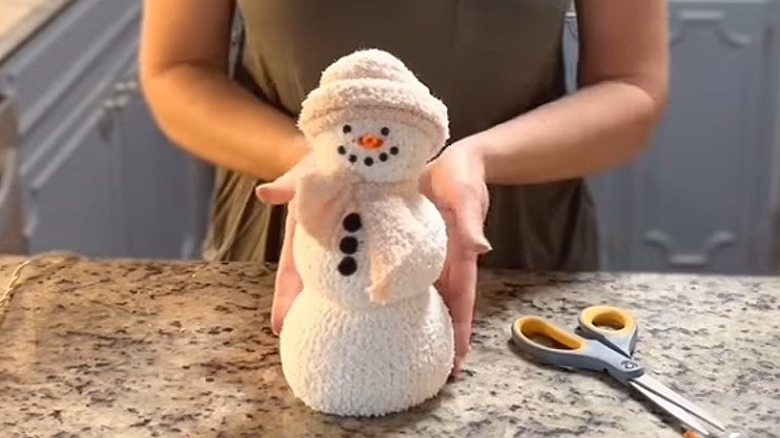 Woman showing DIY snowman sock christmas decor