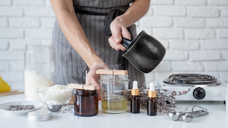 pouring hot wax over candle