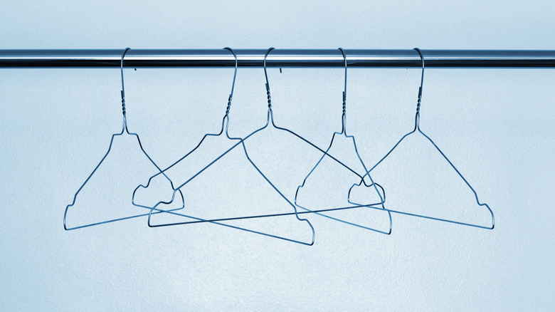 Several wire hangers on rod