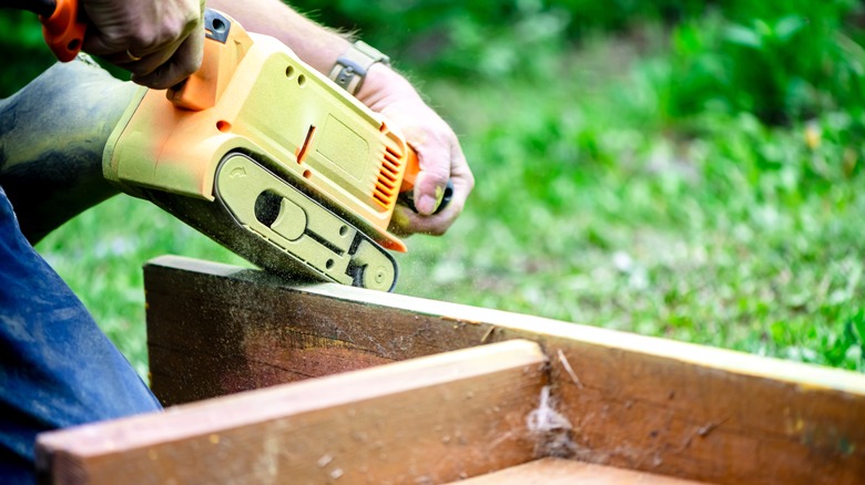 person sanding down cabinet