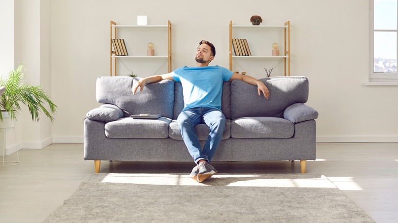 man sits on neat couch 