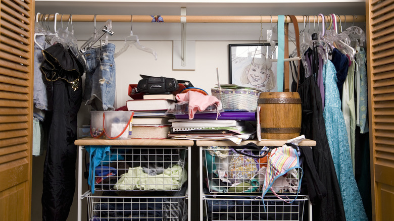 Messy closet with wire baskets and wooden doors