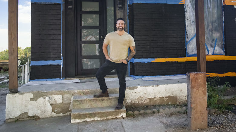 Rico León posing by building