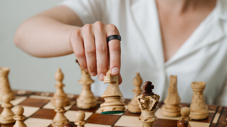 Woman playing chess with RingConn ring