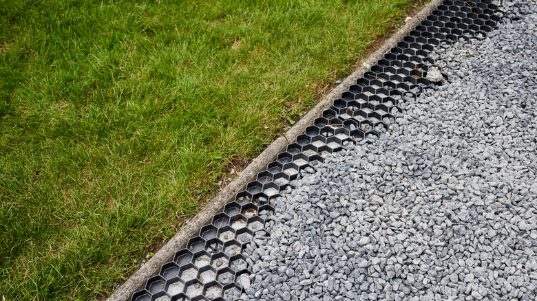 Gravel rocks laid over gravel grid next to grass