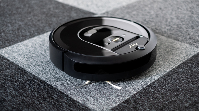 black Roomba on gray carpet