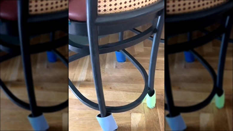 Stool with koozies on the legs functioning as DIY furniture sliders to protect the hardwood floors