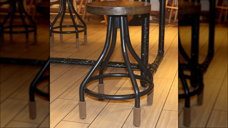 Brown chair socks on a stool with black legs on hardwood floors