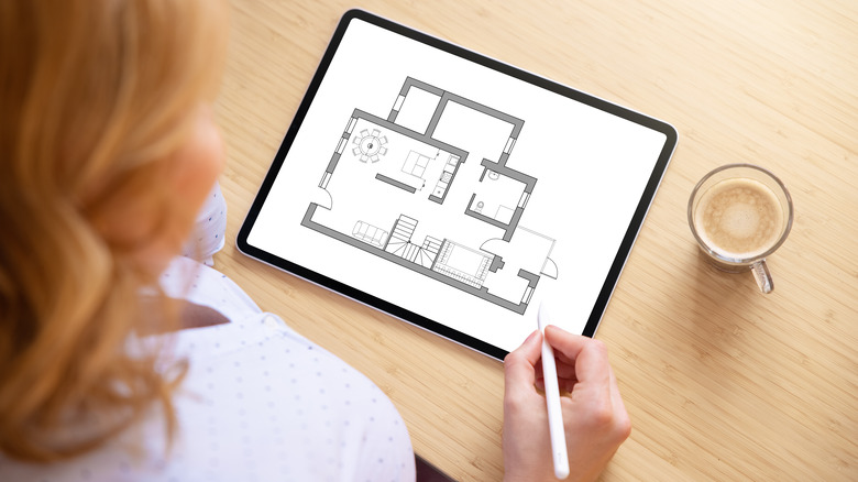 woman drawing floor plan on tablet