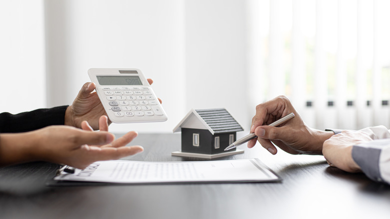 person with paperwork and calculator