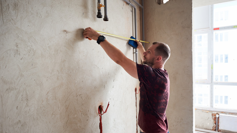 Person measuring wall space