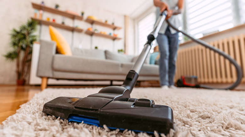 person vacuuming carpet