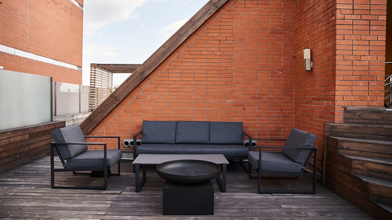 metal patio set on a roof deck with fire pit