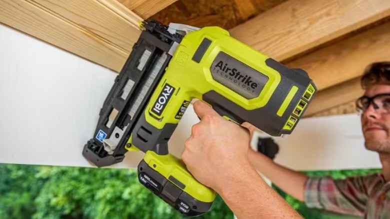 A person using a Ryboi finish nailer on a wooden roof