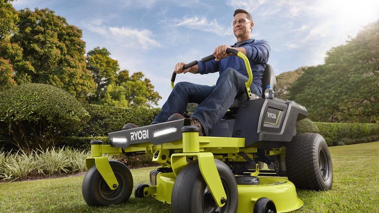 A man riding a Ryobi zero turn electric riding mower