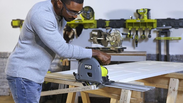 A man using a Ryobi track saw