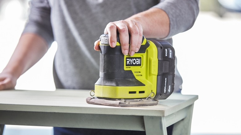 person using Ryobi power sander