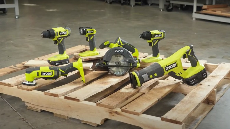 Six Ryobi cordless power tools laying on the floor