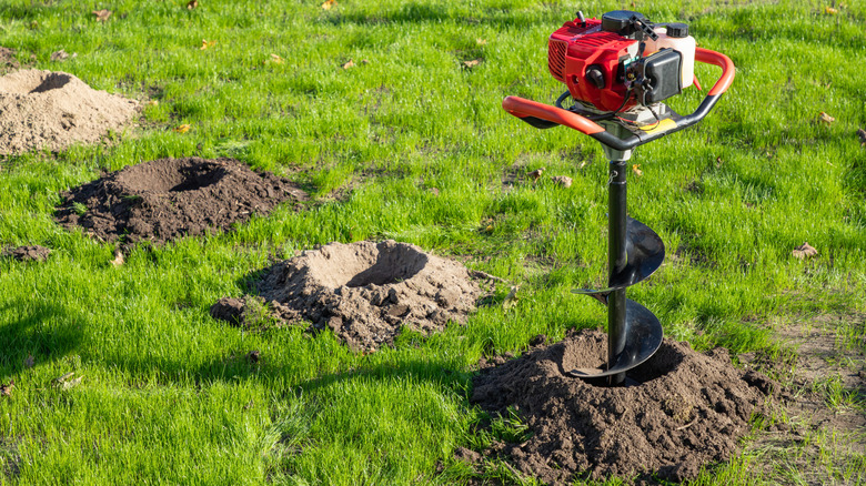 gas-powered auger making holes