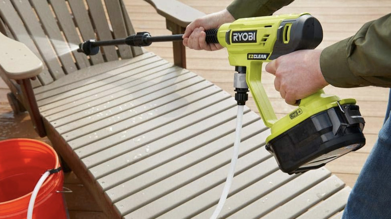 A close up view of a power washer cleaning a patio chair