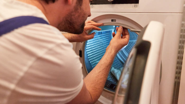 person cleaning dryer