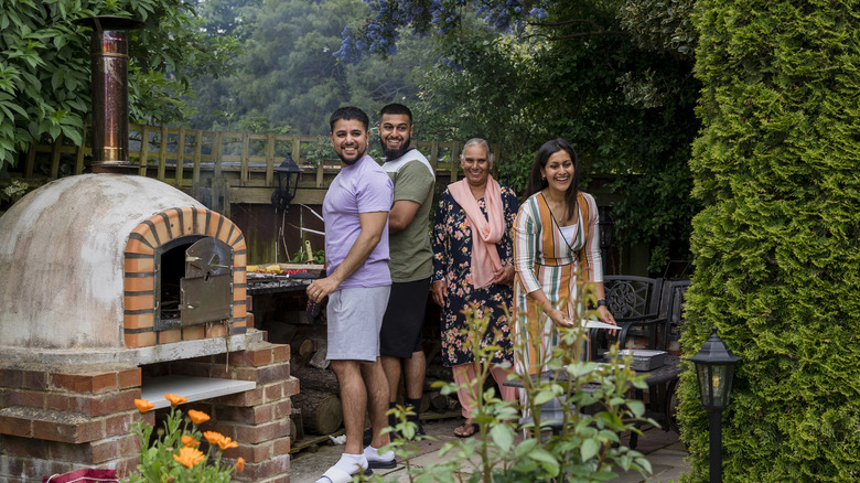 happy family using outdoor pizza oven