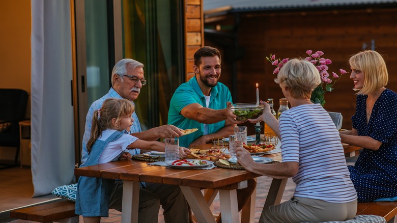 family eating at table outside