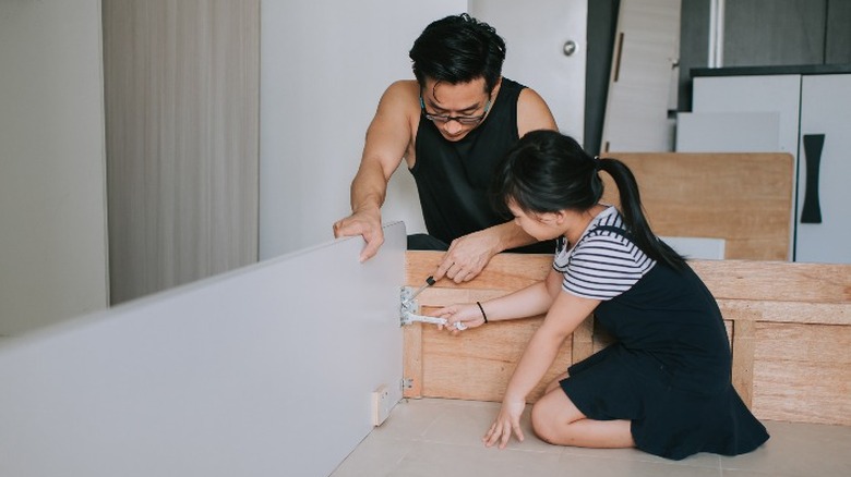 Father and daughter making their bed