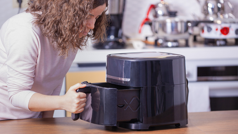 Woman removing air fryer basket