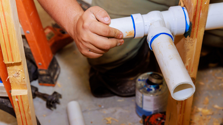 Person gluing pvc pipes together