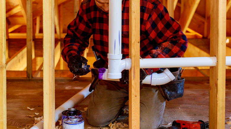 Contractor applying primer to PVC pipe