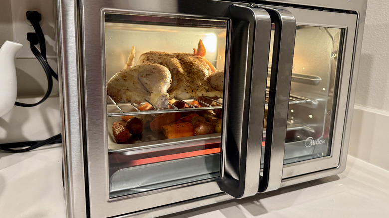 Whole chicken and roasted vegetables cooking in Midea Flexify