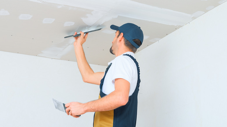 Man applying plaster to ceiling