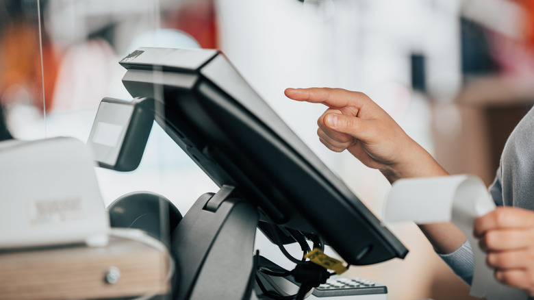 hand holding receipt at cash register