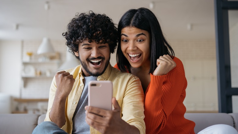 couple looking excitedly at phone