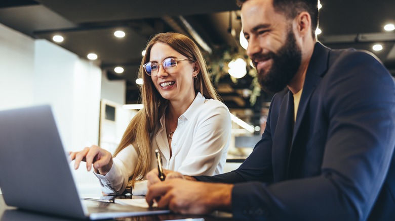 man and woman looking at computer