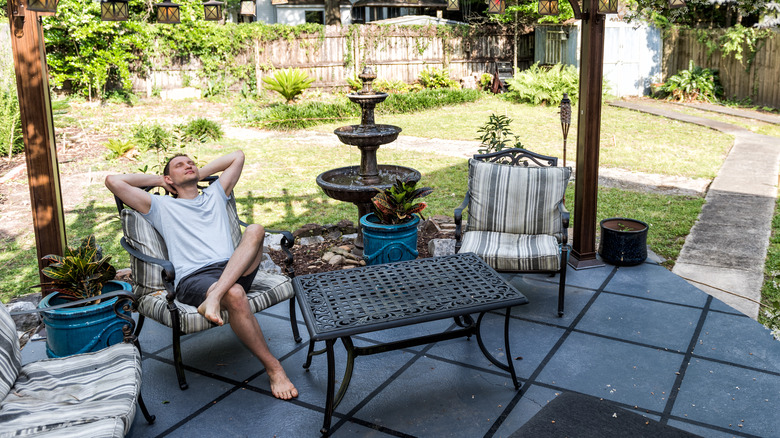 Man relaxing with backyard fountain